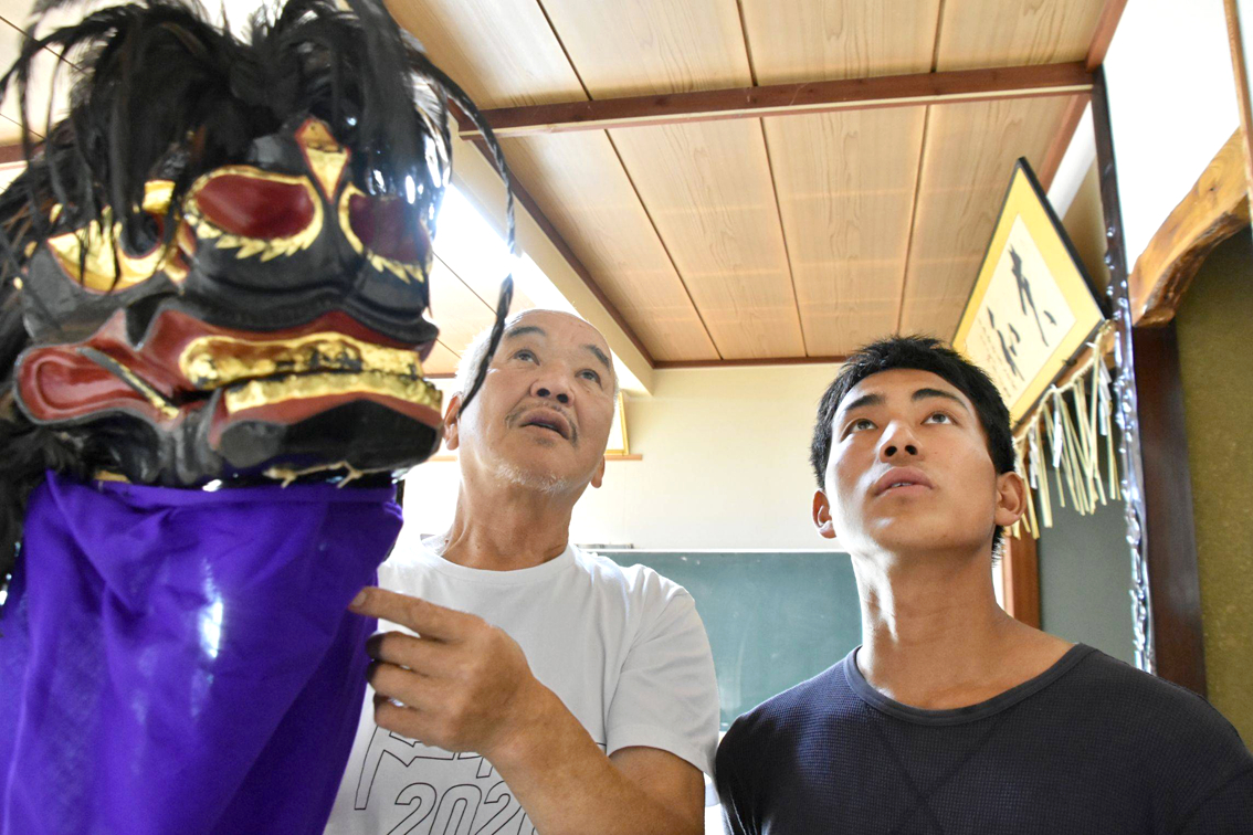 Ông Kenichi Koike (trái) - trưởng nhóm bảo tồn điệu múa sư tử ở Fukushima - giải thích lịch sử của truyền thống này cho Takeo Oshima - một thành viên mới của nhóm - Nguồn ảnh: Fukushima Minpo