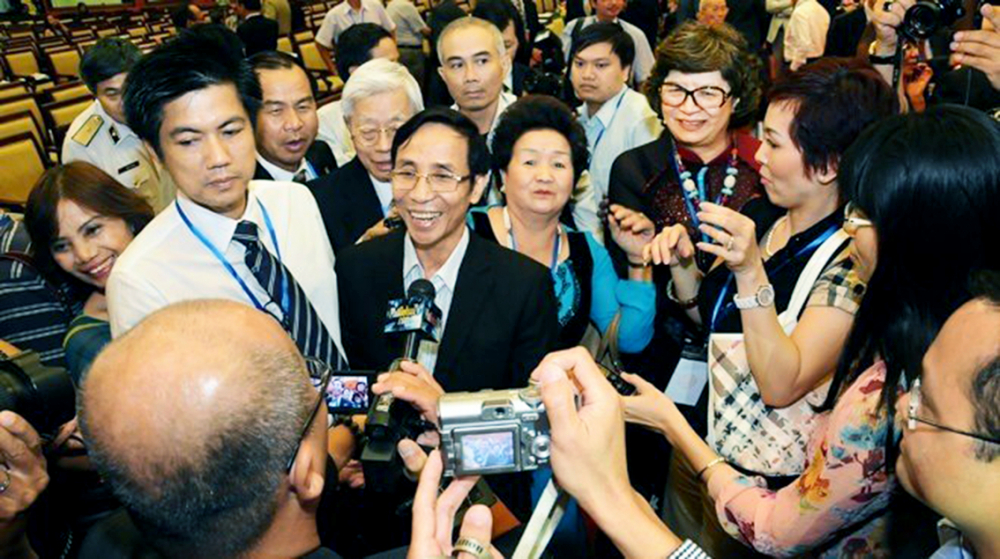 Các kiều bào quan tâm, bày tỏ cảm xúc với Trung tướng Nguyễn Thanh Tuấn (giữa) sau khi nghe bài nói chuyện của ông tại Hội nghị người Việt Nam ở nước ngoài lần thứ hai năm 2012 - Ảnh tư liệu