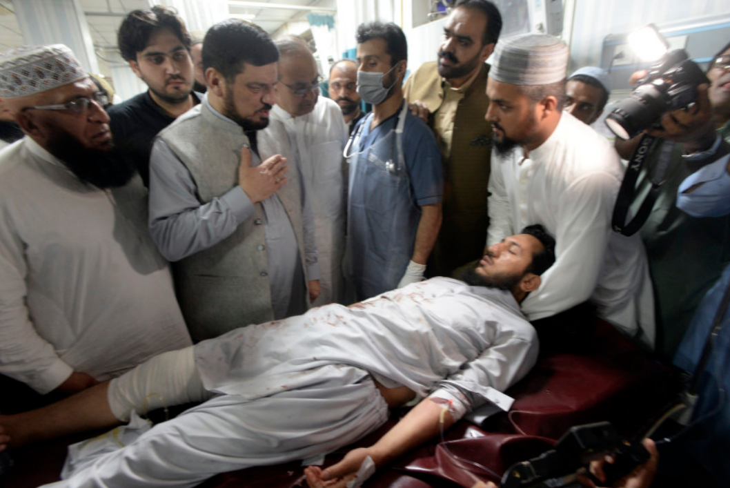 Mọi người vận chuyển một nạn nhân bị thương do một quả bom cực mạnh khi đến bệnh viện ở Peshawar, Pakistan