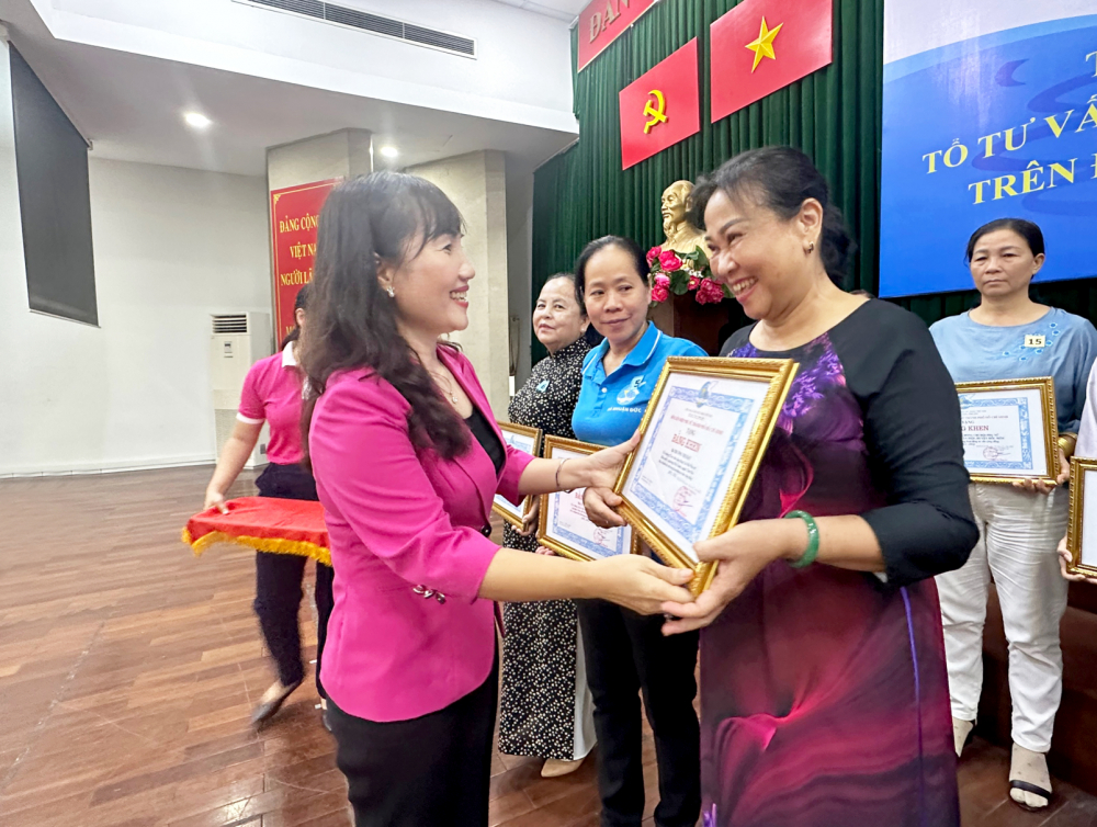 Bà Trịnh Thị Thanh - Phó chủ tịch Hội LHPN TPHCM - tặng bằng khen, ghi nhận sự đóng góp của cô Trương Thị Hậu cho hoạt động tư vấn cộng đồng - ẢNH: DIỄM TRANG