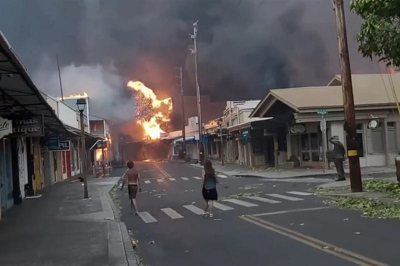 Mọi người đứng nhìn khói và lửa bốc lên từ đám cháy dữ dội trên Phố Front ở trung tâm thị trấn Lahaina, Maui.