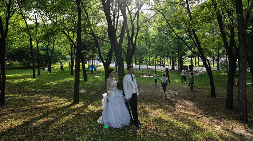 Các cặp vợ chồng trẻ trên khắp Trung Quốc đang đón nhận xu hướng cổ điển bằng cách thông báo về cuộc hôn nhân của họ trên báo thay vì trên mạng xã hội. ẢNH: AFP