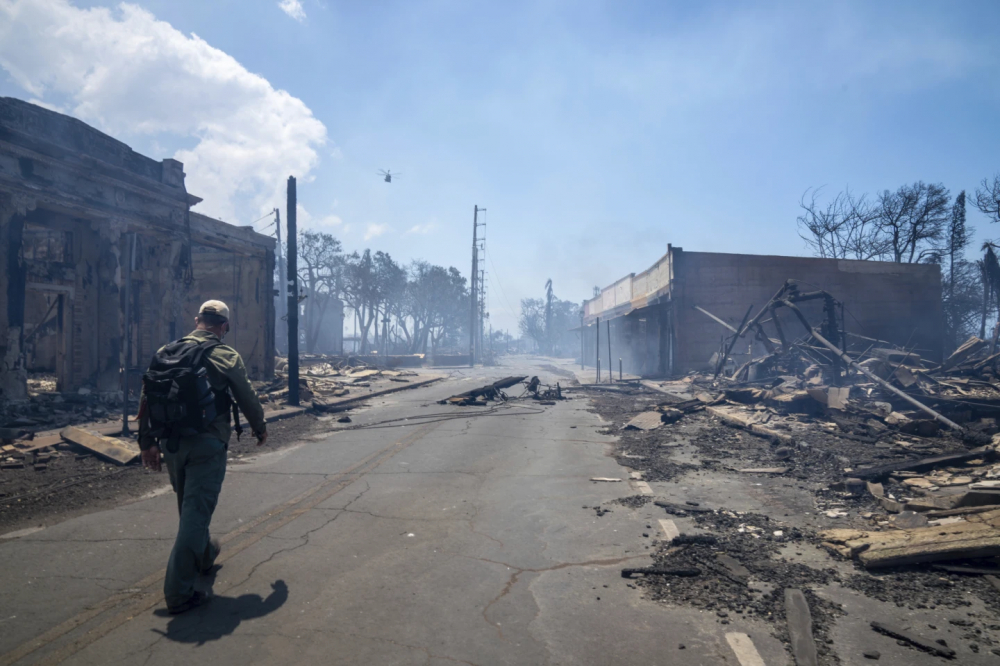 Người đàn ông đi ngang qua đống đổ nát của trận cháy rừng vào ngày 9/8, tại Lahaina, Hawaii- Ảnh: AP