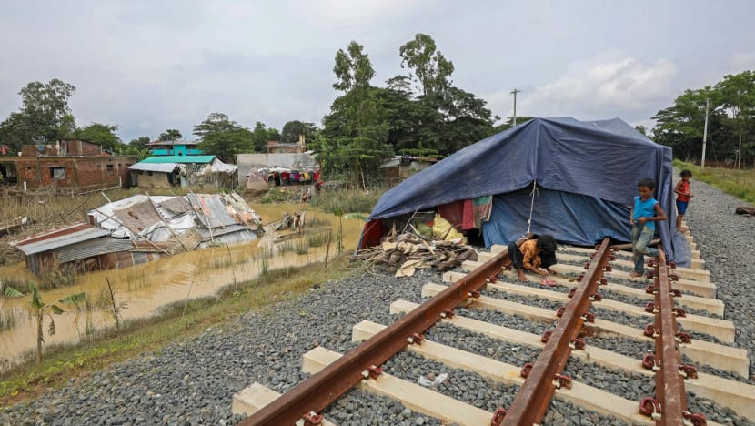 Những người bị ảnh hưởng bởi lũ lụt trú ẩn trên đường ray sau trận mưa lớn ở Satkania