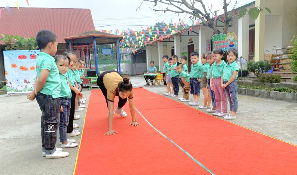 Cô giáo Trường mầm non Bản Lầu (huyện Mường Khương, tỉnh Lào Cai) hướng dẫn trẻ vận động - ẢNH: M.T.