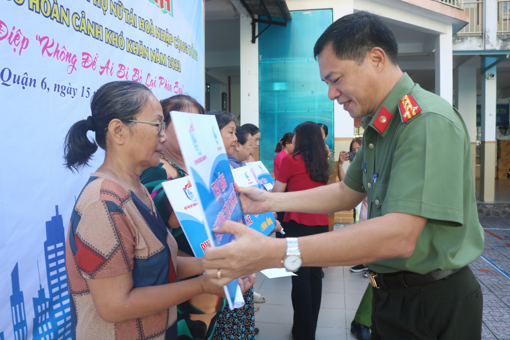 Đại tá Lê Viết Tiệp - Chánh văn phòng Đảng ủy Công an TPHCM - trao bảng tượng trưng hỗ trợ sinh kế cho phụ nữ quận 6. 