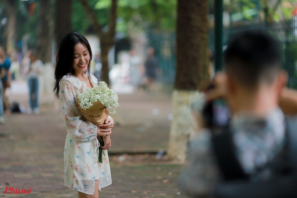 Chỉ đơn giản, nhẹ nhàng với một bó hoa đứng giữa 2 hàng cây sấu già là đủ để có một bức ảnh đẹp của mùa Thu Hà Nội.