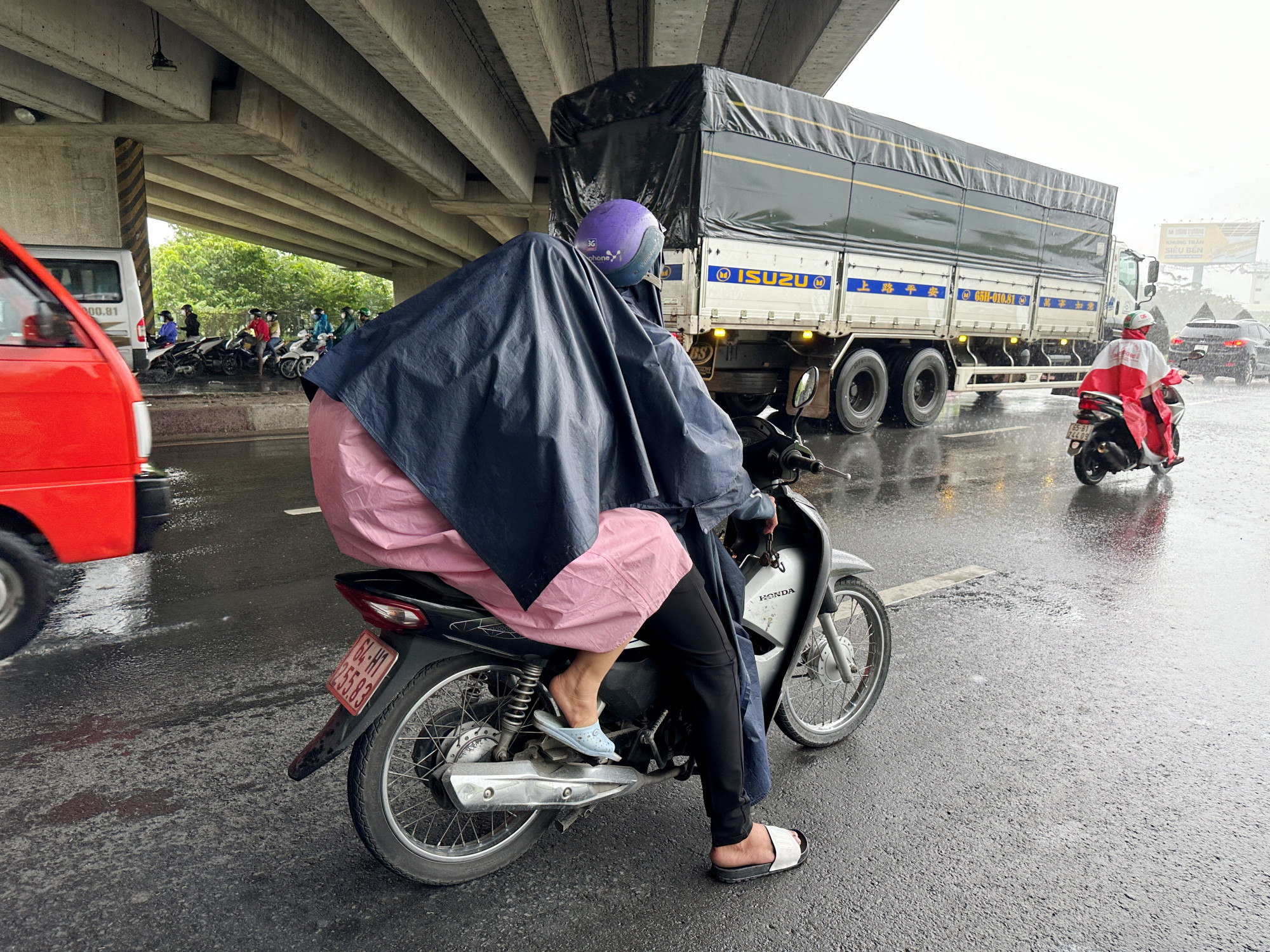 Một xe mô tô dừng giữa lòng đường để trú mưa dưới gầm cầu vượt IC3, tìm ẩn nguy hiểm