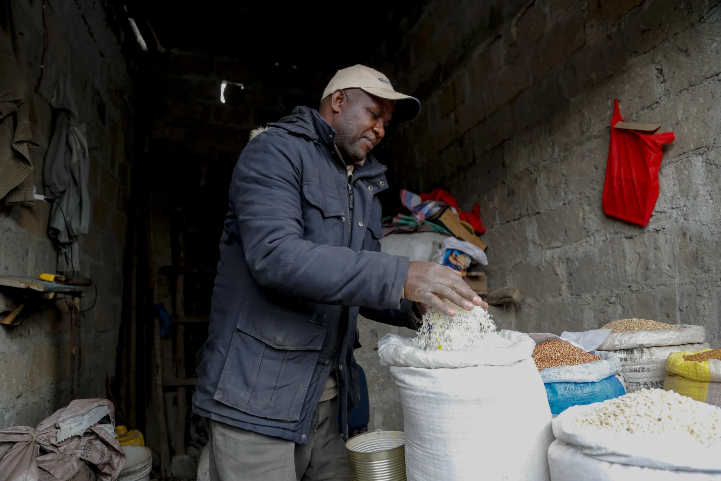 Anh Francis Ndege đong gạo tại cửa hàng của mình ở Nairobi, Kenya