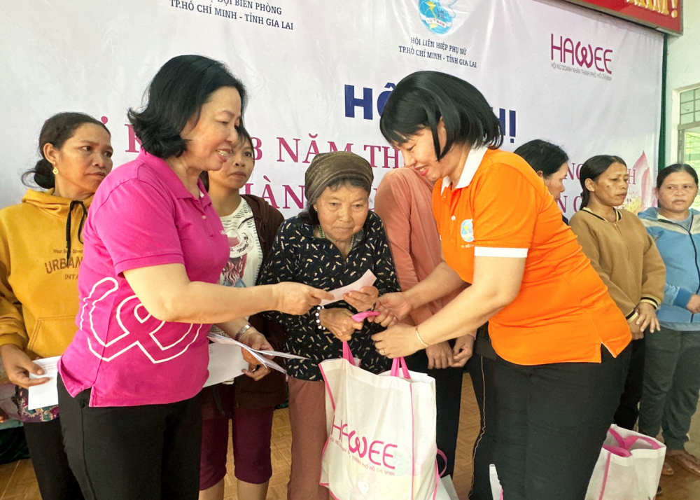 Bà Trần Thị Phương Hoa (bên phải) - Phó chủ tịch Hội LHPN TPHCM - và bà Nguyễn Thị Hạnh (bên trái)  - Phó chủ tịch Hội Nữ doanh nhân TPHCM - tặng quà cho phụ nữ nghèo tại xã Ia Chía