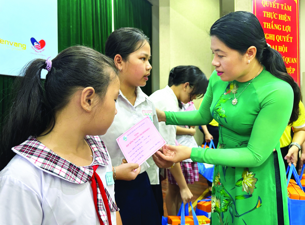 Bà Nguyễn Trần Phượng Trân - Chủ tịch Hội LHPN TPHCM - tặng học bổng Nguyễn Thị Minh Khai cho các em học sinh khó khăn