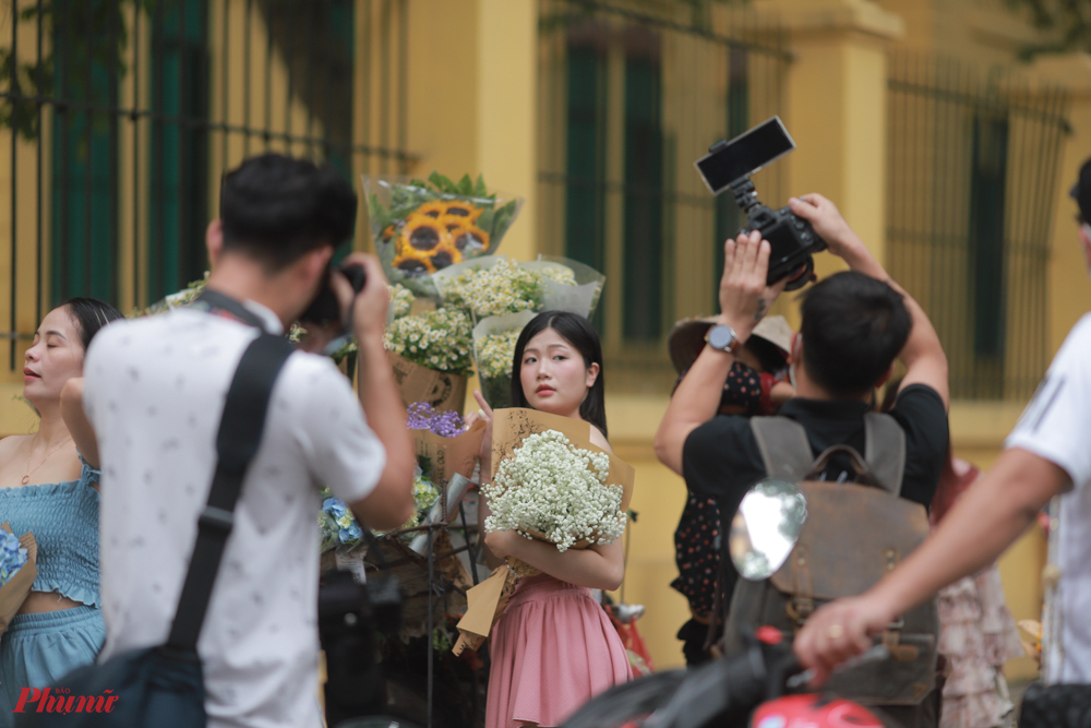 Tại con đường lãng mạn nhất mùa thu Hà Nội - phố Phan Đình Phùng, các xe hoa đứng dày đặc sặc sỡ sắc màu như gánh cả mùa thu xuống phố. Các cô gái trẻ rất thích mua một bó hoa rồi tạo dáng chụp ảnh bên những chiếc xe hoa đậm màu Hà Nội.