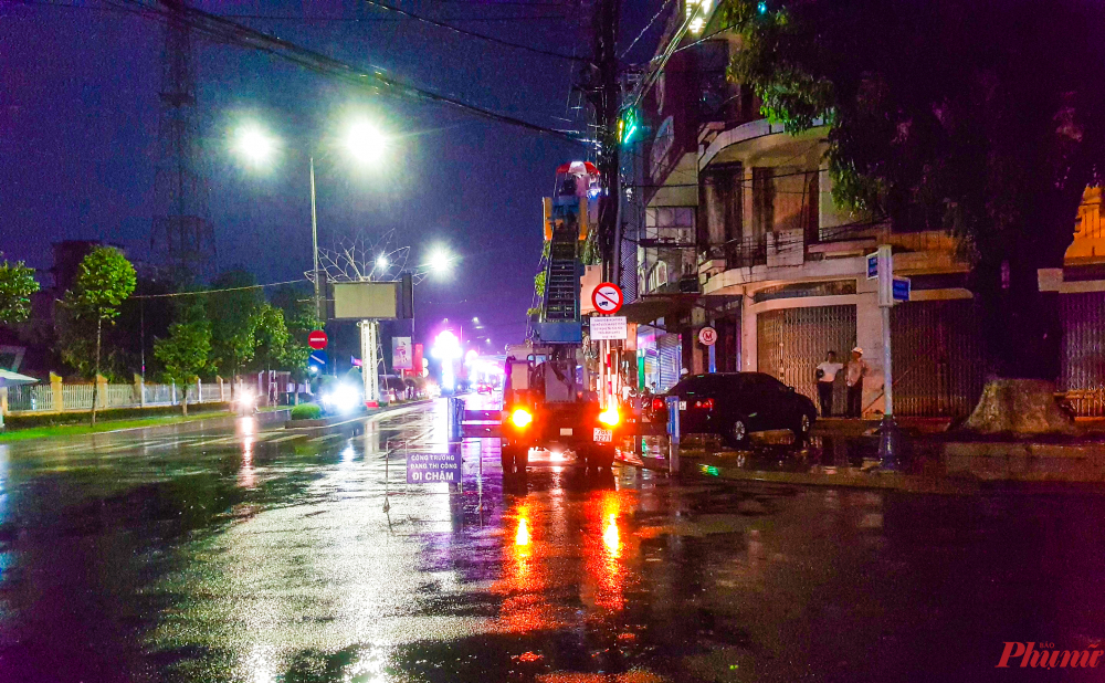 Nhiều khu vực tại thành phố Quảng Ngãi mất điện cục bộ khiến nhân viên điện lực đội mưa sửa điện