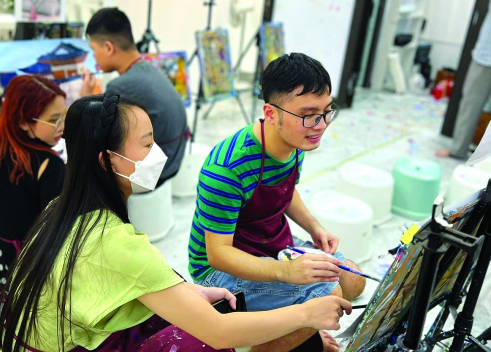 Chàng thanh niên Nguyễn Trung Hiếu (bìa phải) trong lớp học vẽ
