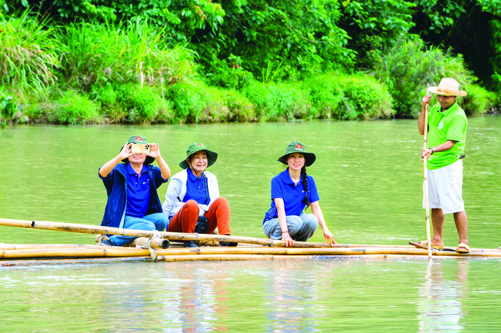 Tác giả (thứ hai từ trái sang) tham gia vượt sông bằng bè nứa
