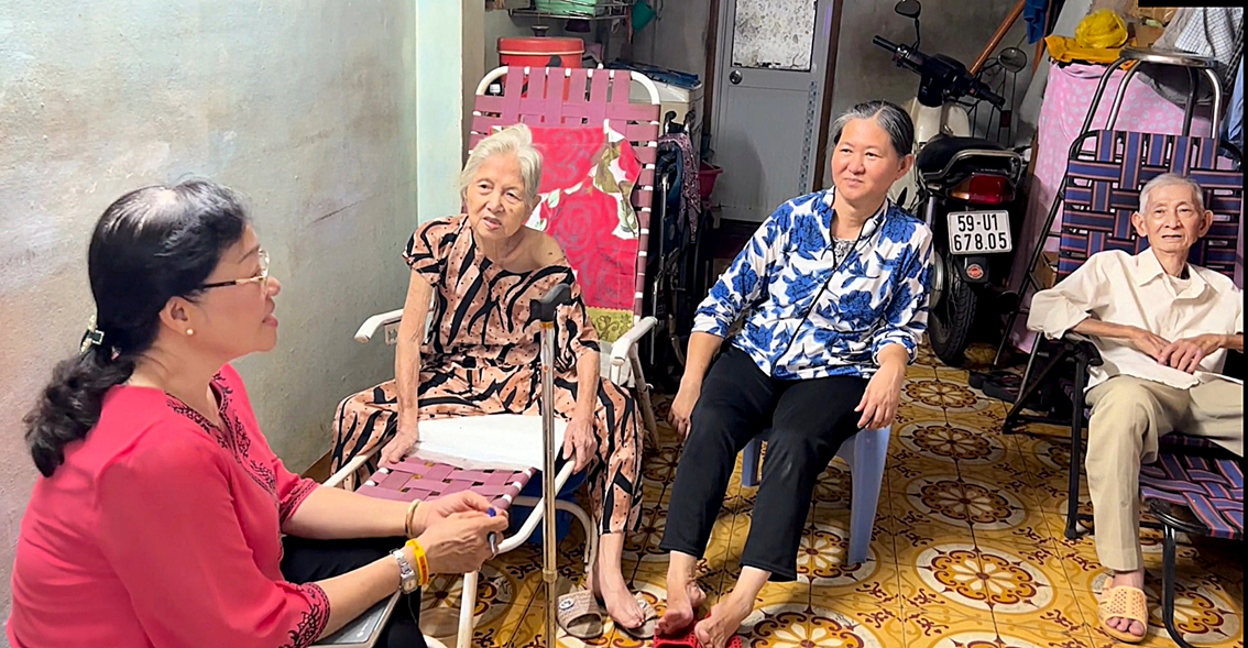 Bà Trần Thị Huỳnh Mai (bìa trái) - Tổ trưởng Tổ tư vấn cộng đồng  khu phố 3, phường 8, quận 10 - đến thăm hỏi gia đình  ông Tăng Trần Huy và bà Lương Ngũ Muội - ẢNH: N.T.