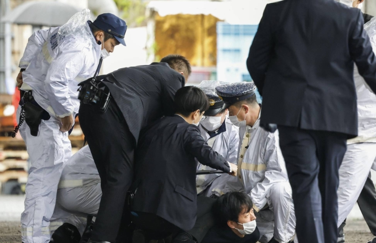 Ryuji Kimura bị khuất phục sau khi bị cáo buộc ném bom ống vào Thủ tướng Fumio Kishida trước khi ông chuẩn bị có bài phát biểu tại một cảng cá ở thành phố Wakayama vào ngày 15 tháng 4. | KYODO JIJI