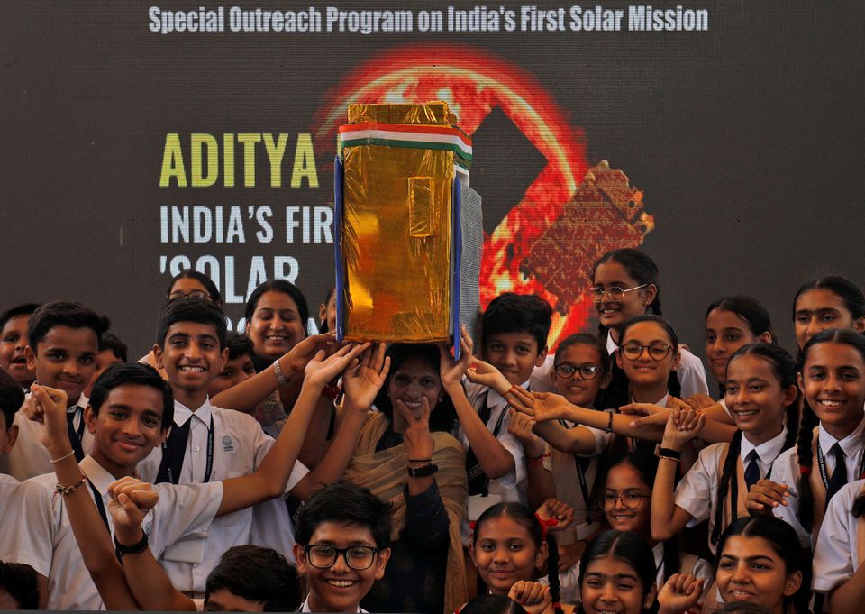 Học sinh Ấn Độ bên cạnh mô hình tàu vũ trụ Aditya-L1 - Ảnh: Amit Dave/Reuters 