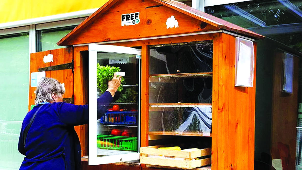 Một phụ nữ đang lấy thức ăn trong tủ lạnh công cộng thuộc dự án Free-Go của hiệp hội Eco-Citoyen, ở Giơ-ne-vơ, Thụy Sĩ - Nguồn ảnh: AP