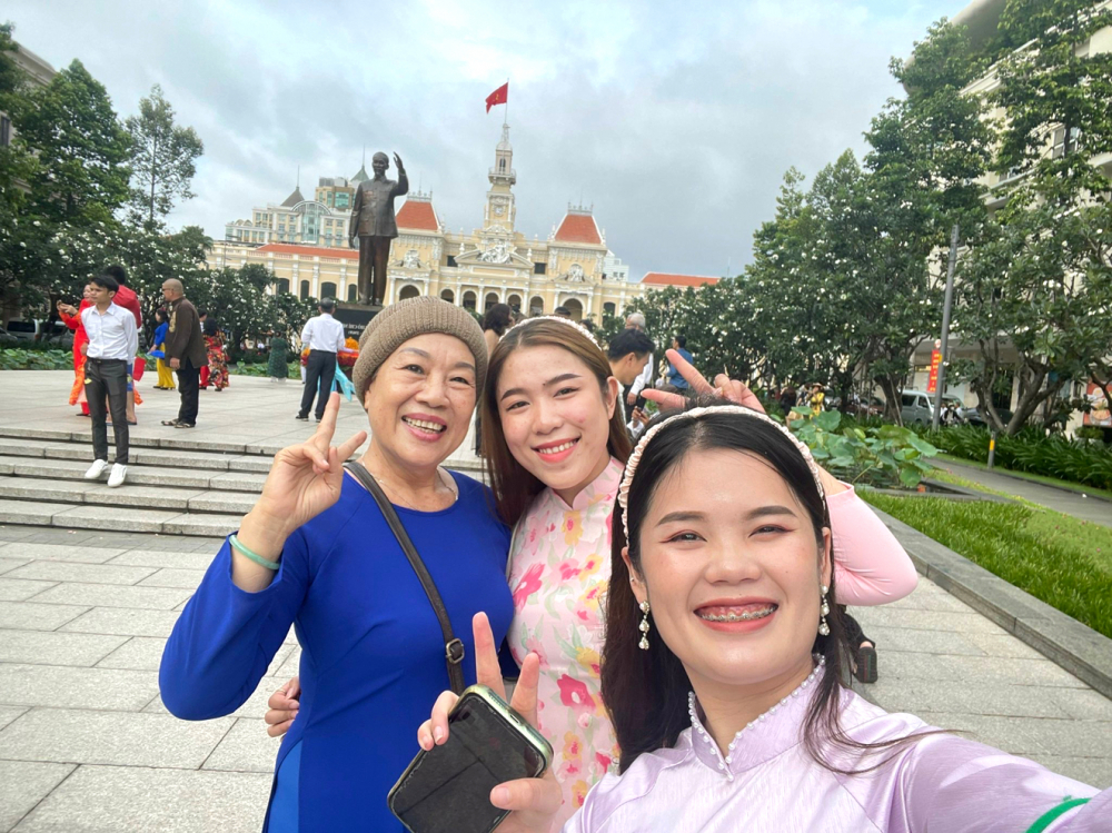 Chị Trần Thị Nhung và 2 “con gái” là sinh viên Lào chụp ảnh lưu niệm phía trước UBND TPHCM 