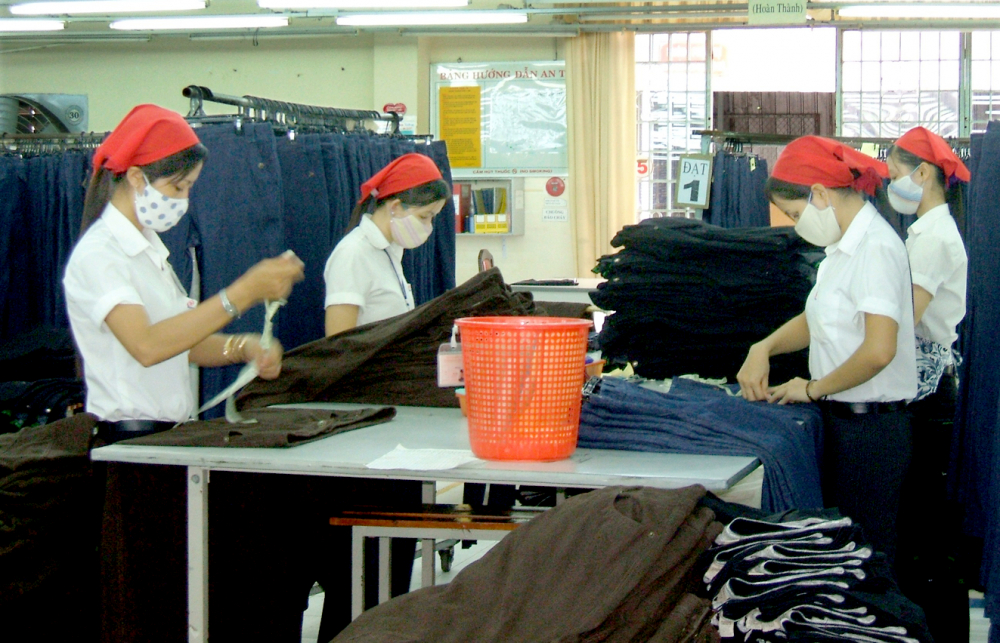 Các nữ công nhân làm việc trong một công ty dệt may ở khu công nghiệp Mỹ Tho, tỉnh Tiền Giang. Làm việc cho doanh nghiệp trong tỉnh nhà giúp họ có điều kiện chăm sóc gia đình - Ảnh: Huỳnh Lợi
