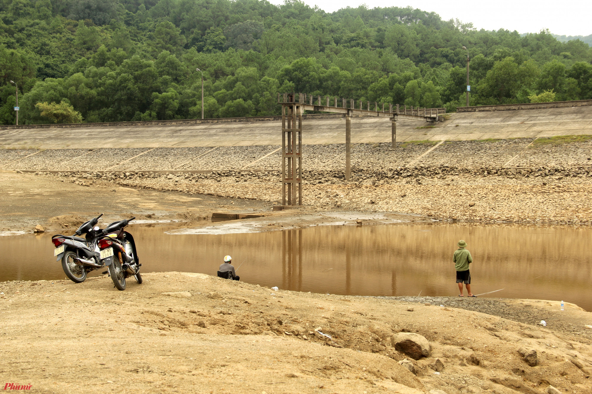 Người dân chạy thẳng xe máy xuống lòng hồ để câu cá.