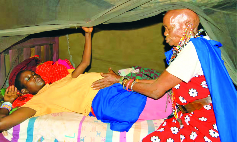 Bà Leitati Rabikon - một bà đỡ truyền thống - đang mát xa cho thai phụ Kevina Kenyaga tại nhà riêng của cô