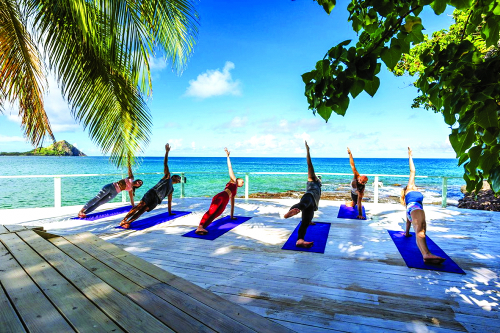 Du khách tập yoga bên bãi biển ở Bodyholiday. Nơi đây có nhiều lớp yoga phù hợp với mọi cấp độ và nhu cầu cụ thể của khách nhằm giúp tăng cường cơ thể và xoa dịu tâm trí  Nguồn ảnh: Bodyholiday
