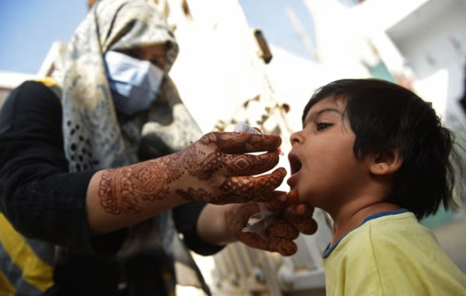 Một nhân viên y tế nhỏ giọt vắc xin bại liệt cho một đứa trẻ ở Karachi. Ảnh: Rizwan Tabassum/AFP/Getty Images