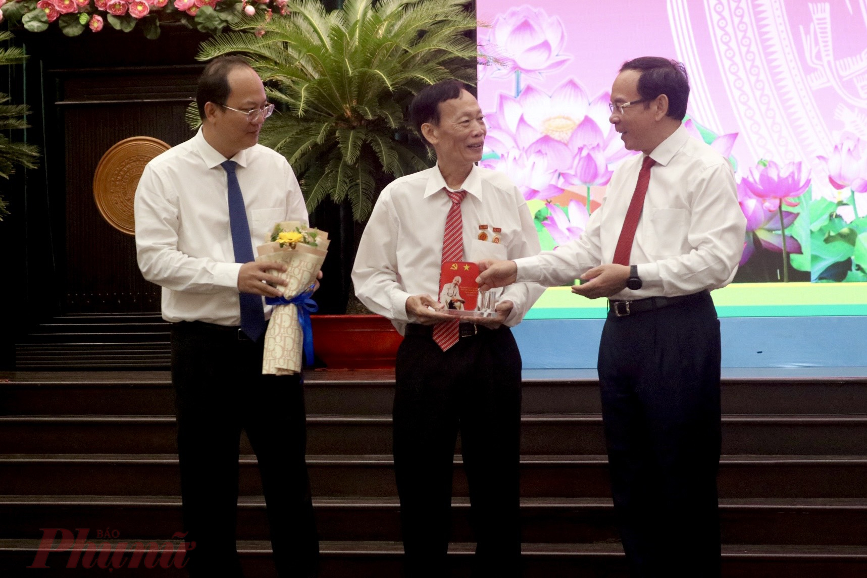 Ông Tạ Việt nhận kỷ niệm chương và hoa từ Bí Thành uỷ TPHCM Nguyễn Văn Nên (bìa phải) và Phó Bí thư Thành uỷ TPHCM Nguyễn Hồ Hải (bìa trái)