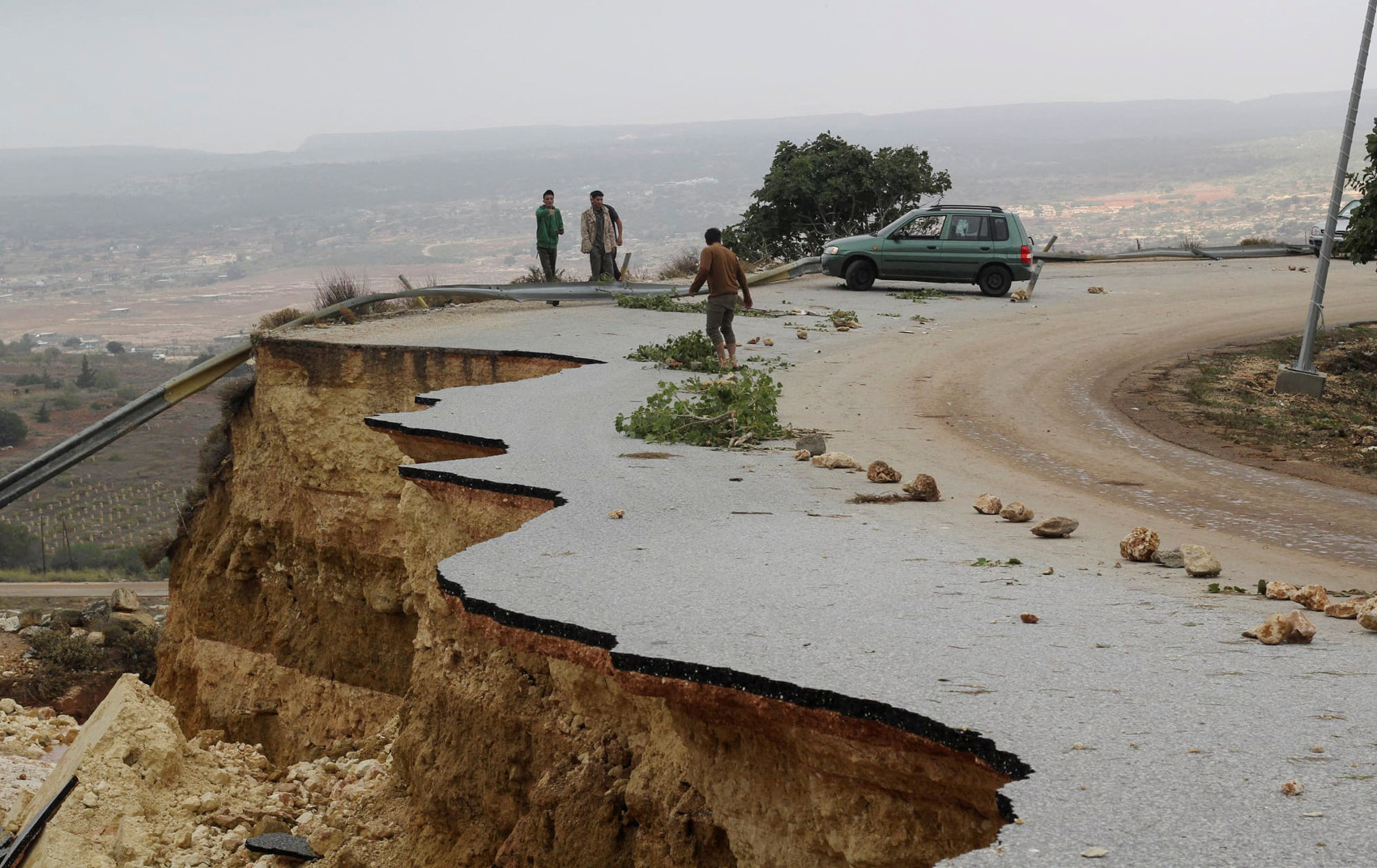 Người dân đứng trên con đường bị hư hỏng khi một cơn bão mạnh gây lũ lớn ở Libya, 11/9.