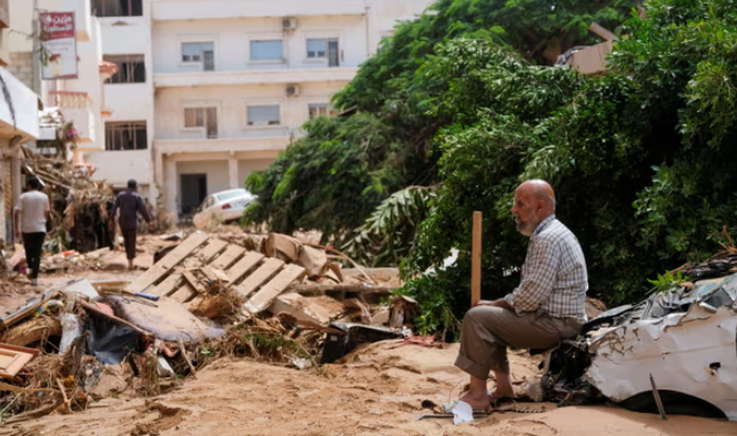 Một người đàn ông ngồi giữa thiệt hại do lũ lụt ở Derna, Libya. Ảnh: Esam Omran Al-Fetori/Reuters