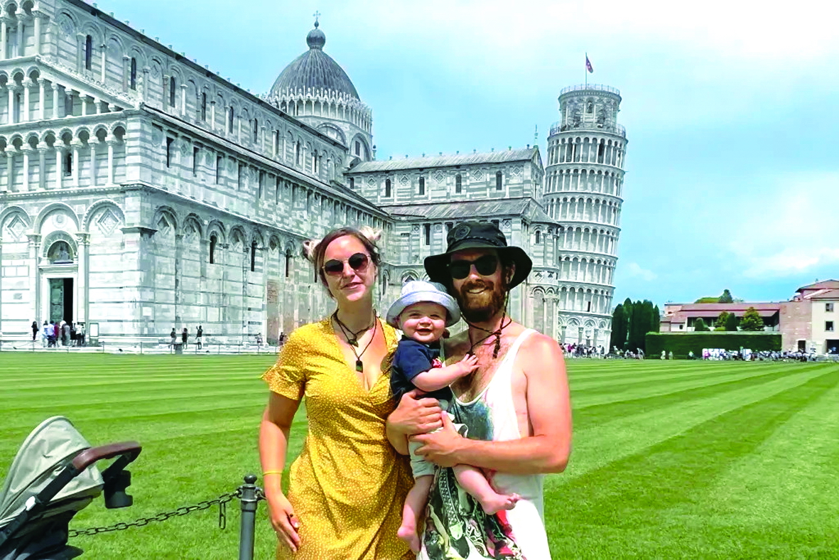 Chưa tròn 1 tuổi, Atlas Montgomery đã được đi du lịch khắp thế giới cùng ba mẹ. Trong ảnh: Vợ chồng Becs - Will và bé trai Atlas chụp ảnh ở tháp nghiêng Pisa, Ý - ẢNH: BECS LEWIS (SWNS)