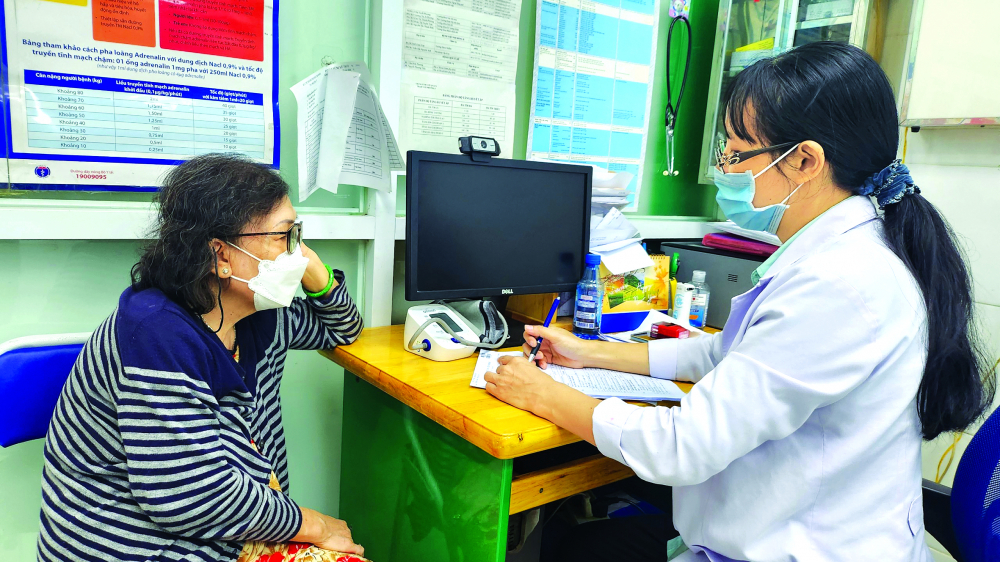 Tầm soát bệnh để nâng cao chất lượng sống cho người già Bác sĩ tư vấn sức khỏe cho người bệnh sau khi khám miễn phí tại Trạm Y tế phường 5, quận 3, TPHCM - Ảnh: Phạm An