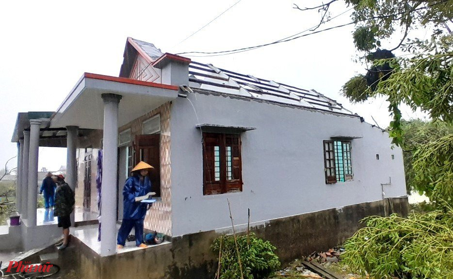 Người dân Quảng Thành cùng lược lượng bộ đội giúp dân lợp lại mái nhà