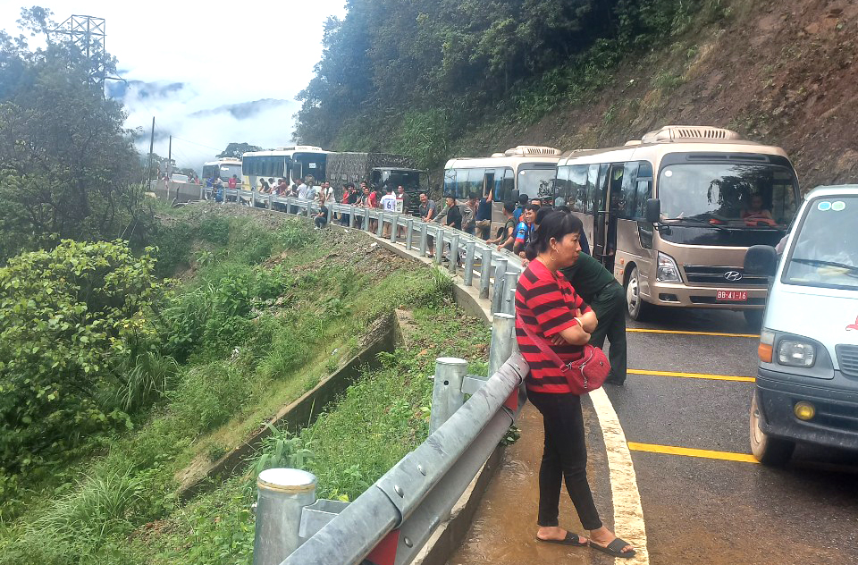 Các phương tiện lưu thông trên quốc lộ 8 buộc phải xếp hàng chờ đợi lực lượng chức năng khắc phục sạt lở đất - Ảnh: Quang Tĩnh