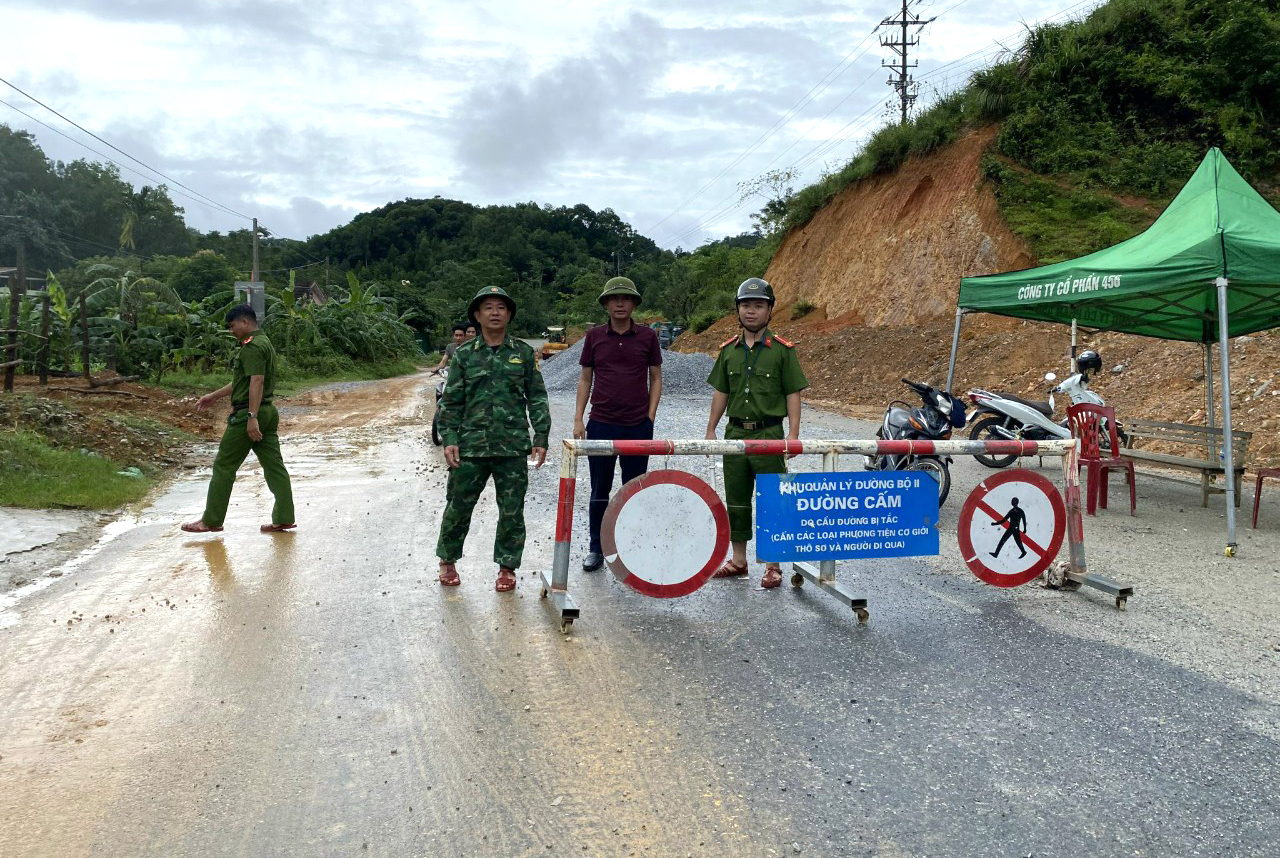 Lực lượng chức năng túc trực cấm người và phương tiện qua lại khu vực bị sạt lở - Ảnh: Quang Tĩnh