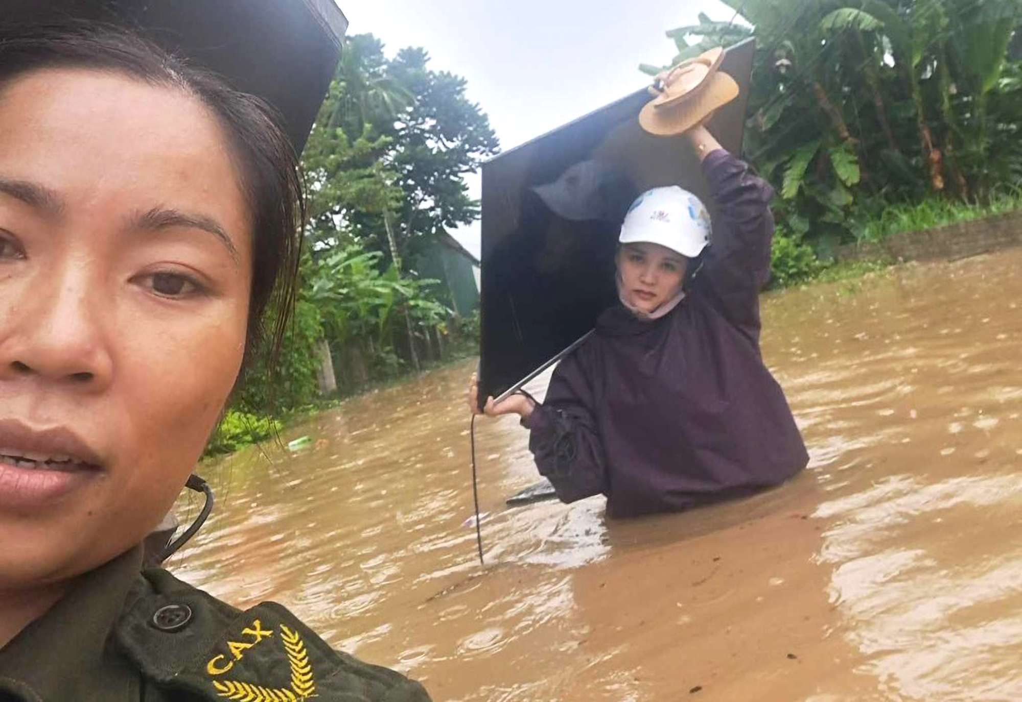 Giáo viên Trường mầm non xã Châu Tiến, huyện Quỳ Châu di dời tivi đến nơi cao ráo - Ảnh: Nguyễn Bình