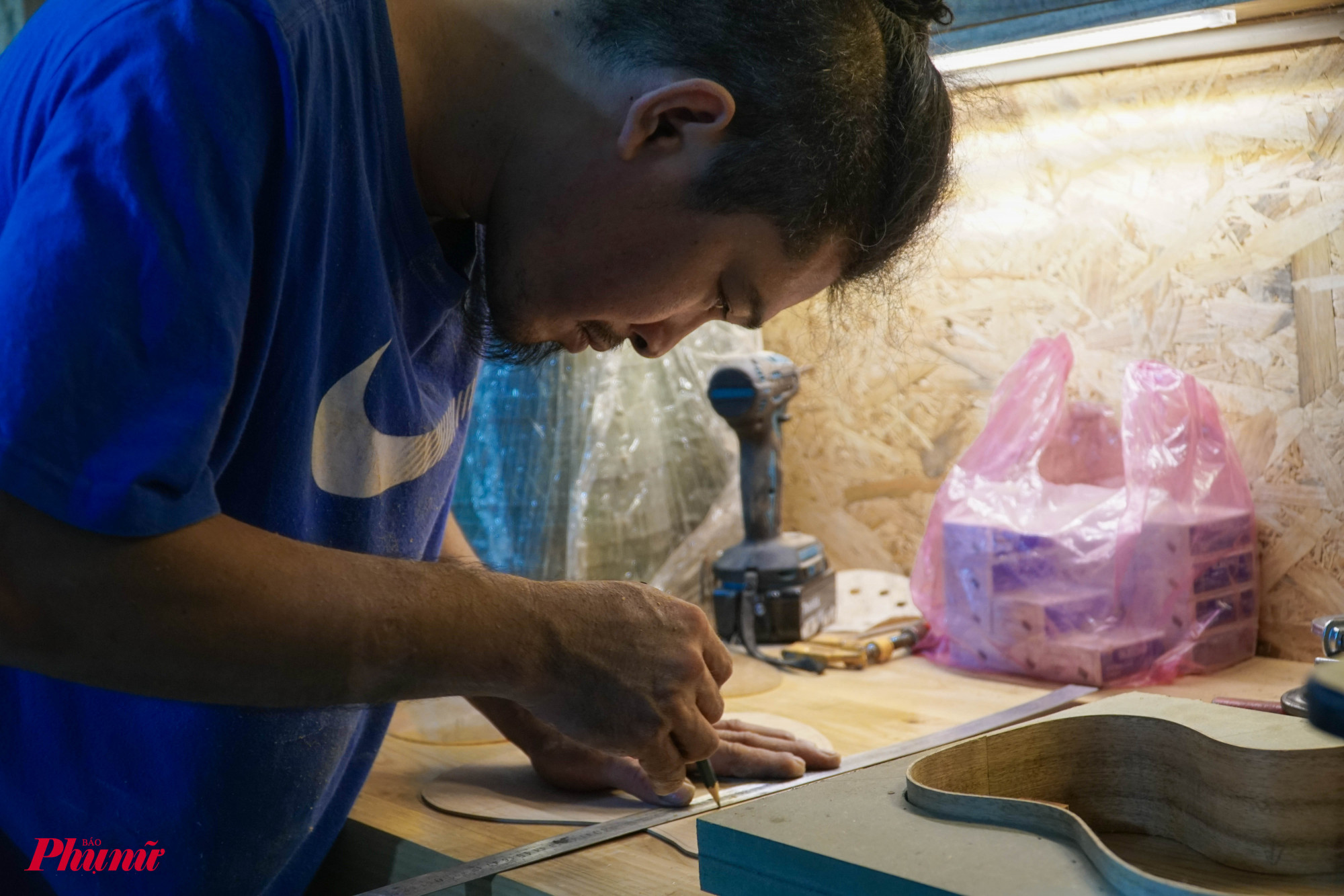 Anh Bửu Thăng đang vẽ khung cho đàn ukulele của dự án