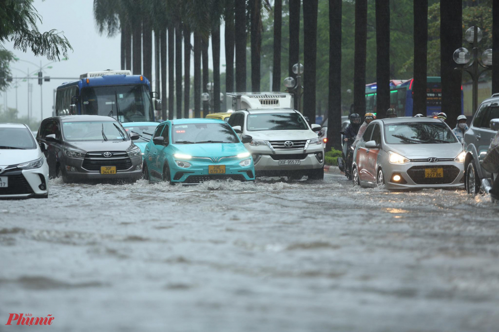 Hàng loạt phương tiện kẹt cứng, chậm rãi băng qua làn nước ngập sâu.