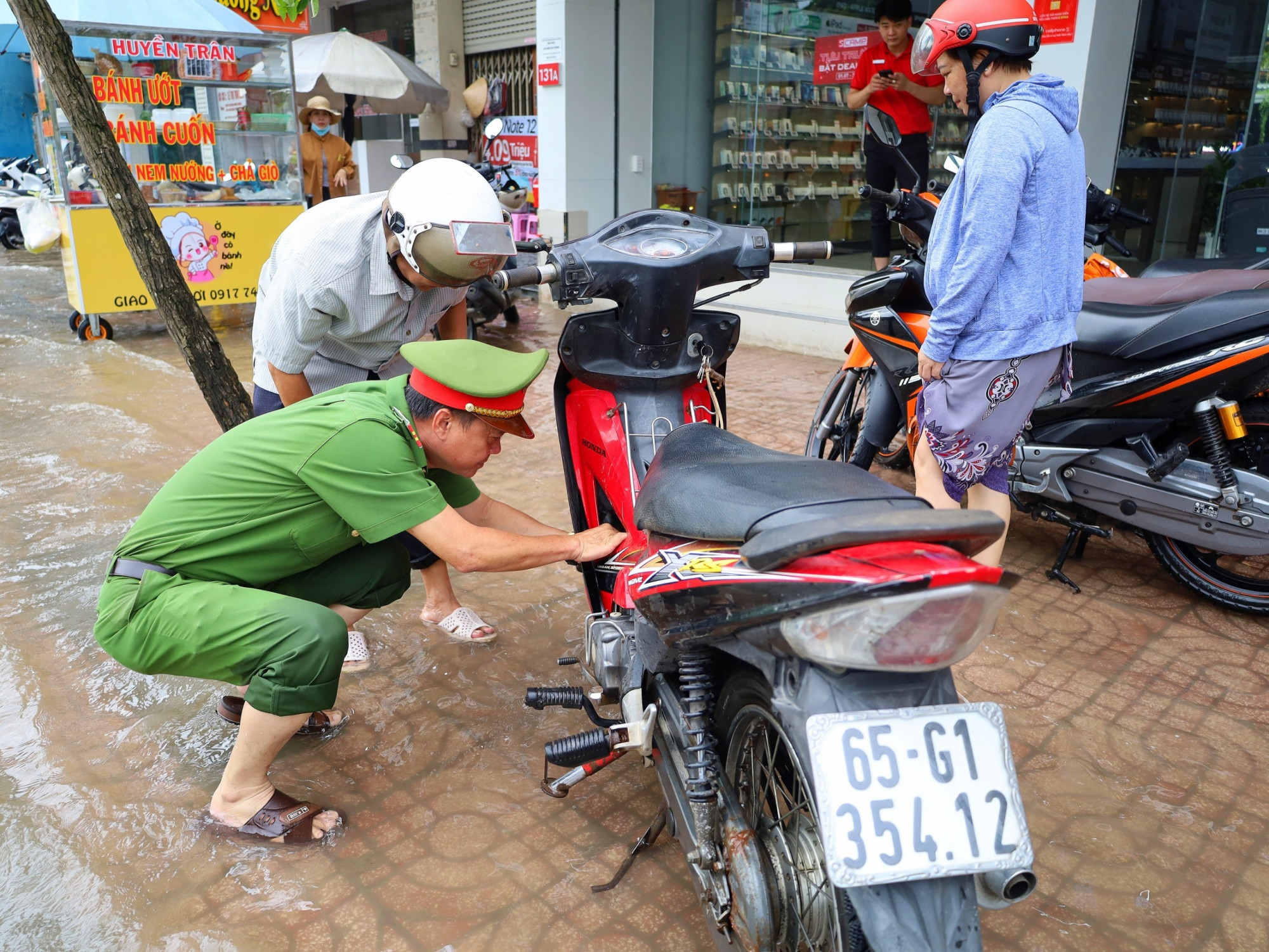 Cảnh sát hỗ trợ giúp một trường hợp xe bị chết máy khi vượt triều cường