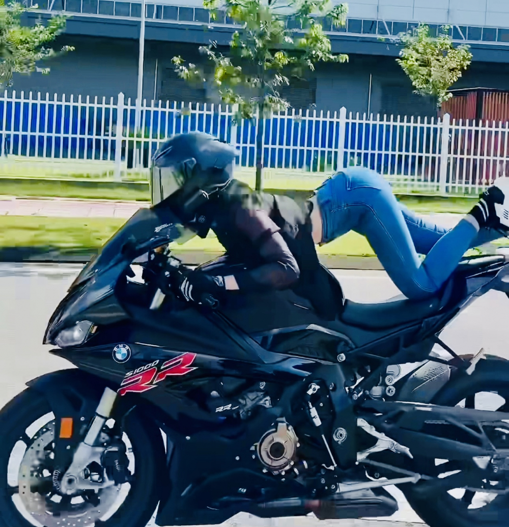 Cô gái biểu diễn trên xe mô tô khi đang đi trên đường khá nguy hiểm.