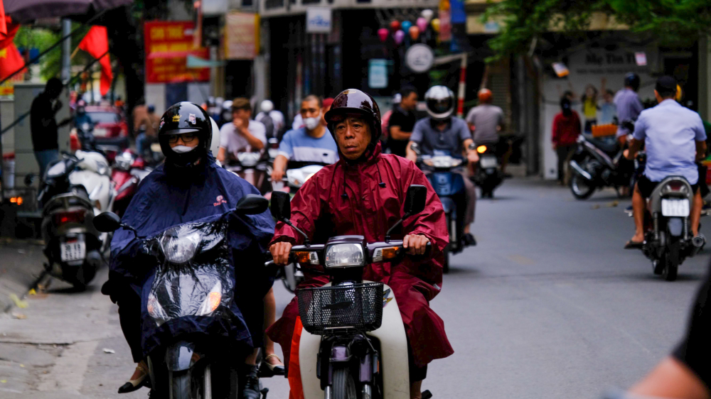 Nhiều người không kịp chuẩn bị áo khoác đã phải sử dụng áo mưa để che chắn những cơn gió lạnh đầu mùa.