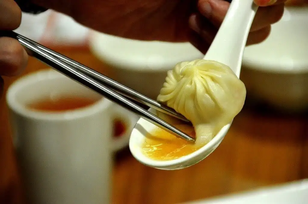 6. Ăn tại Din Tai Fung, nhà hàng bánh bao ngon nhất Đài Bắc Người ta nói rằng bạn chưa từng thử bánh bao tiểu long bao trừ khi bạn đã nếm thử món bánh này ở Din Tai Fung , một chuỗi nhà hàng có từ những năm 1970 và được thành lập bởi Bing Yi-Yang, người đã chuyển đến Đài Loan khi còn trẻ . Năm 2010, chi nhánh Hồng Kông đã giành được sao Michelin – ngôi sao đầu tiên dành cho một nhà hàng Đài Loan – và hiện có các nhà hàng ở Mỹ, Châu Âu và Trung Đông.   Mẹo lập kế hoạch:  Nơi tốt nhất để thử món bánh bao là chi nhánh ở chân tòa nhà Đài Bắc 101 - một nhà bếp có vách kính cho phép du khách quan sát các đầu bếp làm việc và nhân viên phục vụ lao khắp sàn nhà hàng mang theo những tháp bánh bao lắc lư. Tôi khuyên bạn nên dùng món bánh bao xiao long bao nguyên bản, mặc dù món súp bò om cũng là huyền thoại.