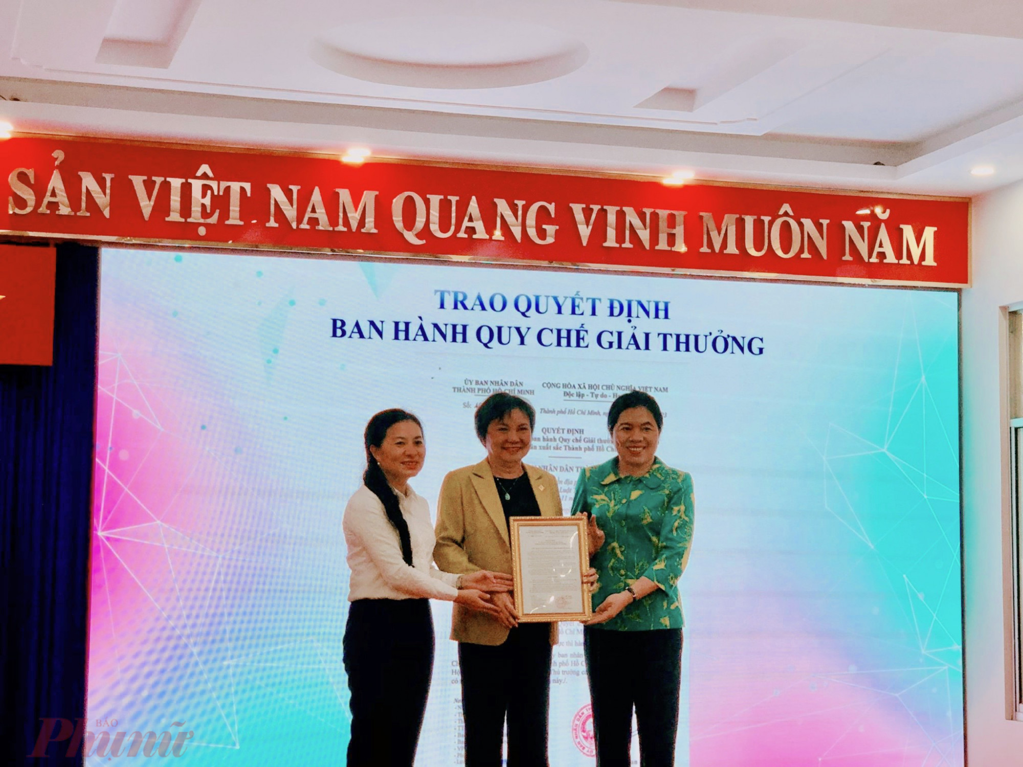 bà Phan Kiều Thanh Hương – Phó giám đốc Sở Nội vụ TPHCM (bên trái) trao quyết định quy chế giải thưởng cho Hawee và Hội LHPN TPHCM