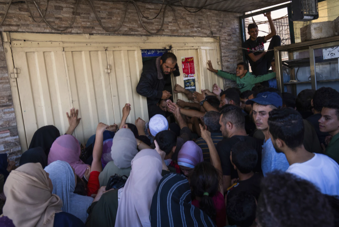 Một đám đông người Palestine chen lấn vào một tiệm bánh để mua bánh mì ở Khan Younis, Dải Gaza, Chủ nhật, ngày 15/10Israel đã cắt nguồn cung cấp thực phẩm đến Gaza sau cuộc tấn công của Hamas vào tuần trước khiến 1.300 người thiệt mạng và các cuộc tấn công trả đũa của Israel đã giết chết hơn 1.300 người. 2.300 người Palestine. (Ảnh AP/Fatima Shbair)