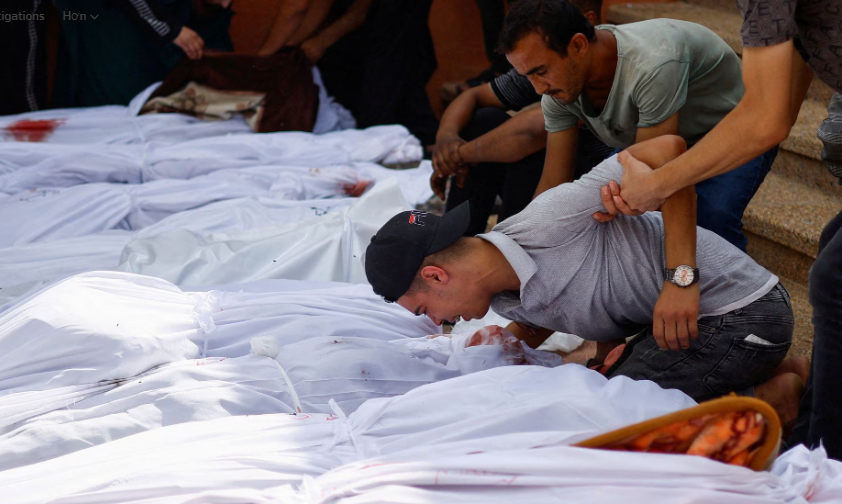 Những người đưa tang đặt tay bên cạnh thi thể của những người Palestine thiệt mạng trong các cuộc tấn công của Israel, tại một bệnh viện ở Khan Younis, phía nam Dải Gaza, ngày 17 tháng 10. REUTERS/Mohammed Salem