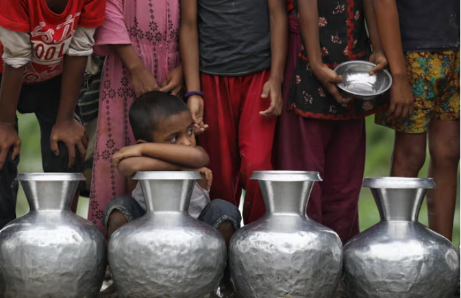 Trẻ em Bangladesh, xếp hàng chờ lấy nước uống an toàn sau lũ lụt ở Sylhet,  năm 2022. Ảnh: Syed Mahamudur Rahman/NurPhoto/Rex/Shutterstock