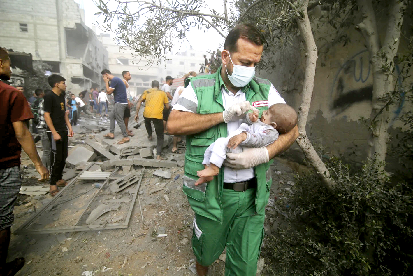 Nhân viên y tế Palestine chăm sóc cho một đứa trẻ vừa được kéo ra khỏi đống đổ nát do bom đạn tại Dải Gaza vào ngày 22/10 - Nguồn ảnh: AP