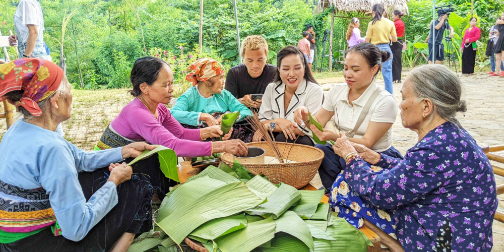 Khách du lịch gói bánh cùng phụ nữ bản Bướt - ẢNH: U.N.